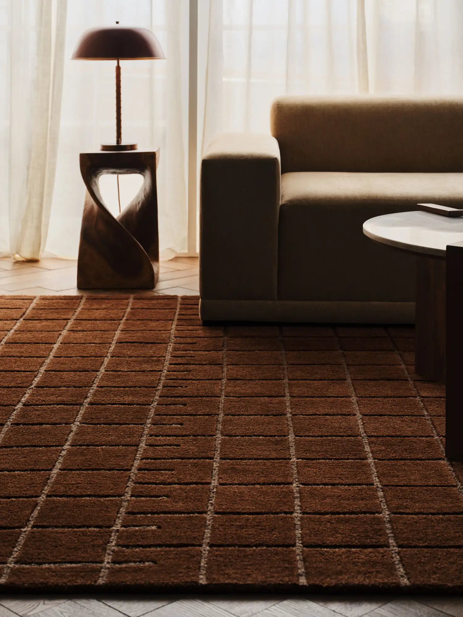 Brown rectangular rug with a grid pattern of lighter brown lines.